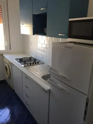 a white kitchen with a stove and a sink at Casa Vacanze Playa 54 in Castellammare del Golfo