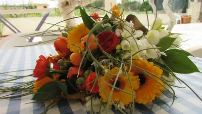 a bouquet of flowers sitting on top of a table at Appartamento Spiaggia Playa in Castellammare del Golfo