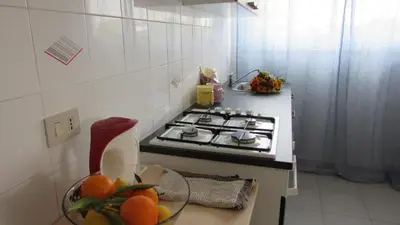 a kitchen with a stove and a bowl of oranges at Appartamento Spiaggia Playa in Castellammare del Golfo