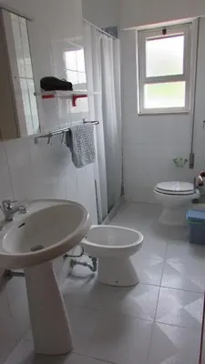 a white bathroom with a sink and a toilet at Appartamento Spiaggia Playa in Castellammare del Golfo