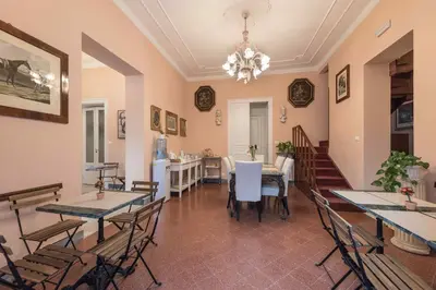 a dining room with tables and chairs and a chandelier at Palazzo Benso in Palermo
