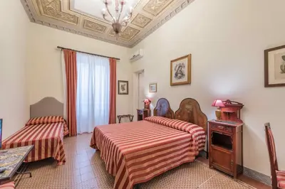 a hotel room with two beds and a table at Palazzo Benso in Palermo