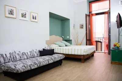 a living room with a couch and a bed at Le Case Moncada in Palermo