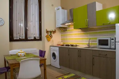 a small kitchen with a table and a microwave at Le Case Moncada in Palermo