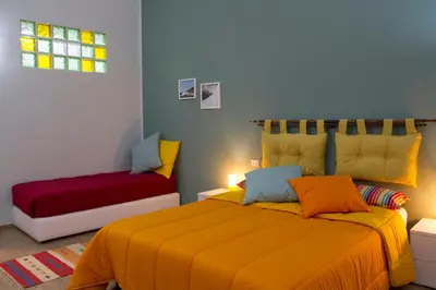 a bedroom with a bed with a yellow blanket at Le Case Moncada in Palermo