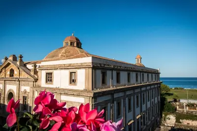 an old building with pink flowers in front of it at Dimora Torremuzza in Palermo