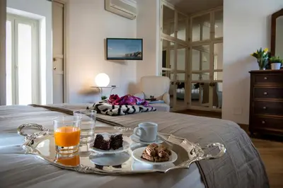 a tray with food and orange juice on a bed at Dimora Torremuzza in Palermo