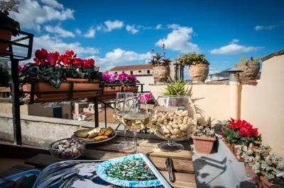 a table with food and wine glasses on a balcony at Dimora Torremuzza in Palermo