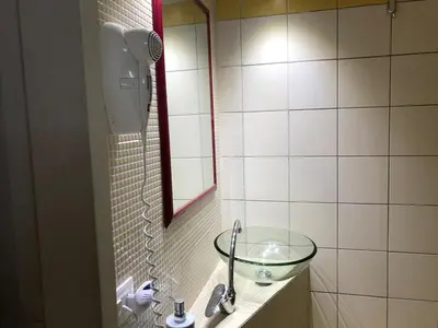 a bathroom with a glass sink and a mirror at Bahalara Alloggio in Palermo