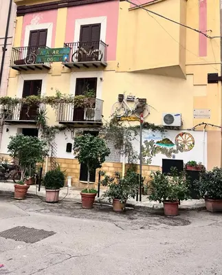 a building with potted plants on the side of it at Bahalara Alloggio in Palermo