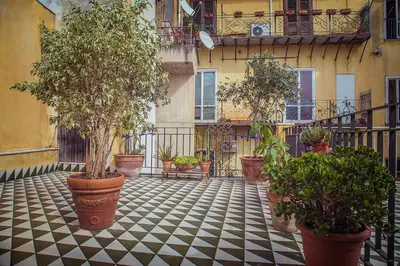 a courtyard with potted plants on a tiled floor at Palazzo Trinacria in Palermo