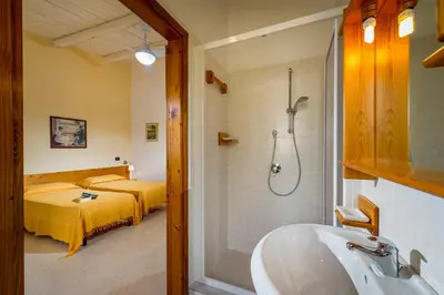 a bathroom with a tub and a bedroom with a bed at Agriturismo Finazzo in Balata di Baida