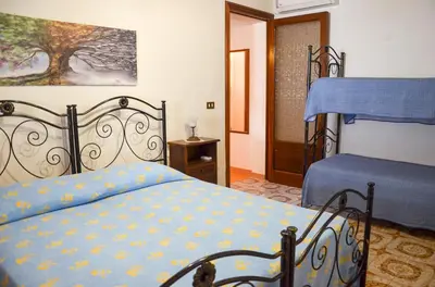 a bedroom with a bed with a blue comforter at La Grande Palma in Castelluzzo