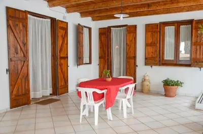 a dining room with a red table and white chairs at La Grande Palma in Castelluzzo