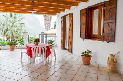 a dining room with a table and chairs on a patio at La Grande Palma in Castelluzzo