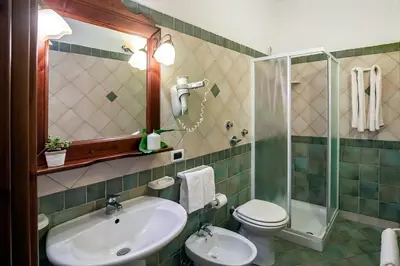 a bathroom with a sink and a toilet and a shower at Alba Marina B&B in Castelluzzo