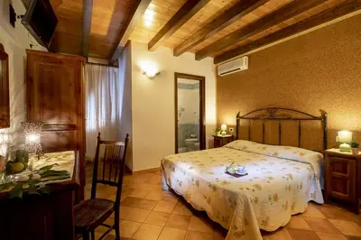 a bedroom with a bed and a table and chairs at Alba Marina B&B in Castelluzzo