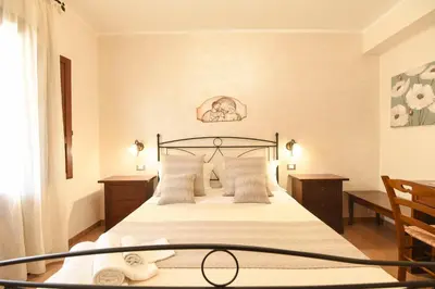 a bedroom with a large bed with white sheets and pillows at Bed & Breakfast Goccia Marina in San Vito lo Capo