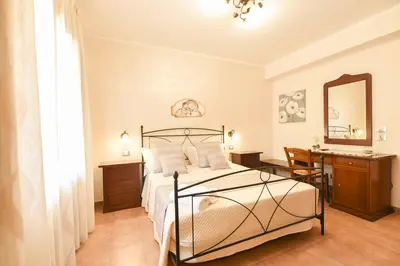 a bedroom with a bed and a desk and a mirror at Bed & Breakfast Goccia Marina in San Vito lo Capo