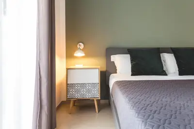 a bedroom with a bed and a night stand next to a window at La Meridiana in Castellammare del Golfo