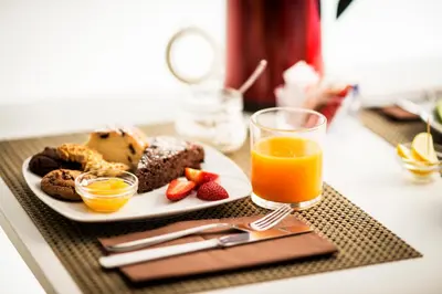 a table with a plate of food and a glass of orange juice at La Meridiana in Castellammare del Golfo