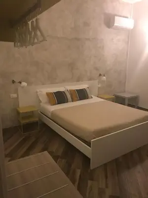a bedroom with a large bed and wooden floors at La Meridiana in Castellammare del Golfo