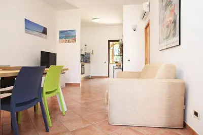 a living room with a table and chairs at Acquamarina32 in San Vito lo Capo