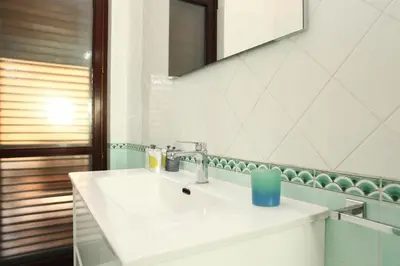 a bathroom with a white sink and a mirror at Acquamarina32 in San Vito lo Capo