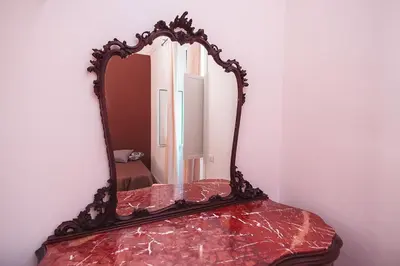 a mirror sitting on top of a red table at B&B L'Orlando Furioso in Palermo