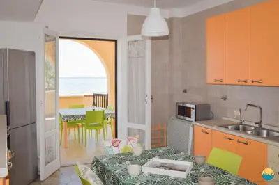 a kitchen with a table and a view of the ocean at Maresole apartments - direttamente sul mare in Alcamo Marina
