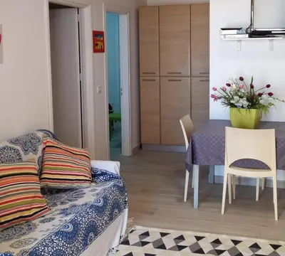 a living room with a couch and a table and chairs at Maresole apartments - direttamente sul mare in Alcamo Marina