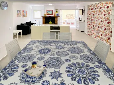 a dining room table with a blue and white patterned rug at Maresole apartments - direttamente sul mare in Alcamo Marina