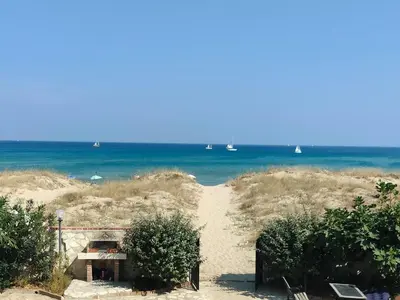 a path to the beach with boats in the water at Maresole apartments - direttamente sul mare in Alcamo Marina