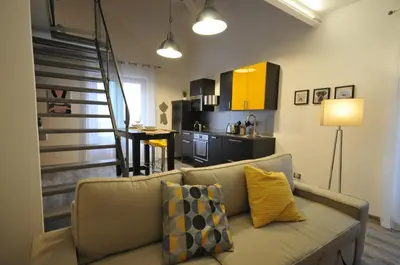 a living room with a couch and a kitchen at Papireto 11 Loft in Palermo
