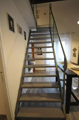 a spiral staircase in a room with a table at Papireto 11 Loft in Palermo