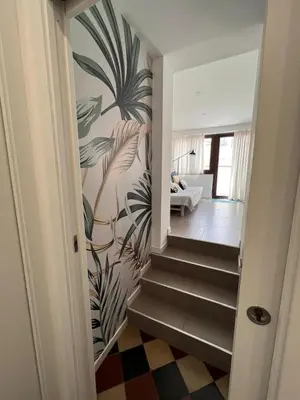 a hallway with a staircase with a mural of a plant at Fiori d'Arancio in Terrasini