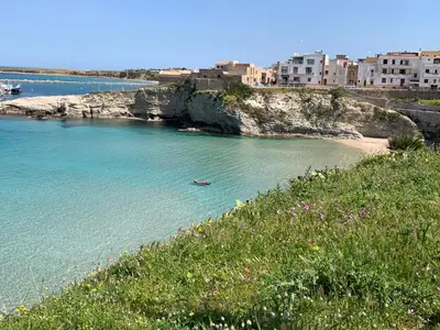 a boat in the water next to a beach at Fiori d'Arancio in Terrasini
