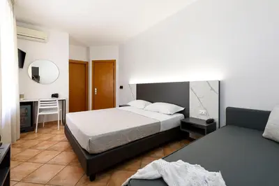 a bedroom with a bed and a table and a desk at Sun Garden in San Vito lo Capo