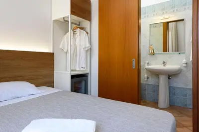 a bedroom with a bed and a sink and a mirror at Sun Garden in San Vito lo Capo