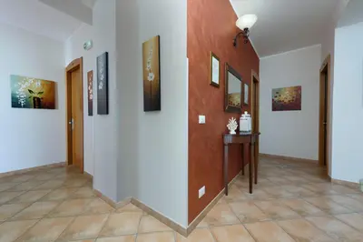 a hallway with paintings on the walls and a table at Sun Garden in San Vito lo Capo