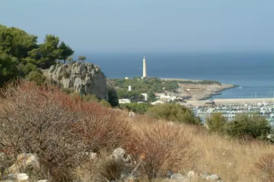 a lighthouse on a hill next to the ocean at Sun Garden in San Vito lo Capo