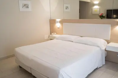a bedroom with a large white bed with two pillows at Hotel Mediterraneo in Palermo