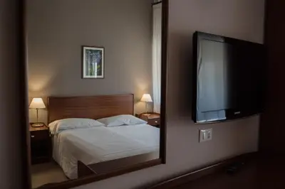 a bedroom with a bed with a mirror and a flat screen tv at Hotel Mediterraneo in Palermo