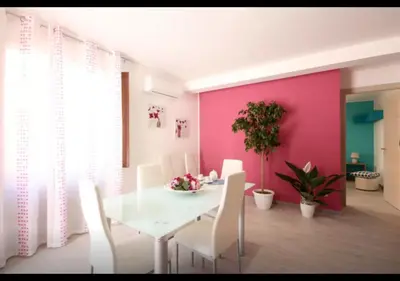a dining room with a white table and white chairs at Rainbow in Castellammare del Golfo
