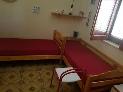 a room with a bed and a bench and a window at Villa del Golfo Urio with swimming pool shared by the two apartments it is essential to have a car in Santa Flavia