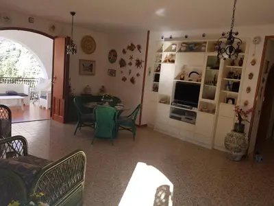 a living room with a table and a dining room at Villa del Golfo Urio with swimming pool shared by the two apartments it is essential to have a car in Santa Flavia