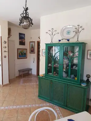 a green cabinet in a room with a table at Villa del Golfo Urio with swimming pool shared by the two apartments it is essential to have a car in Santa Flavia