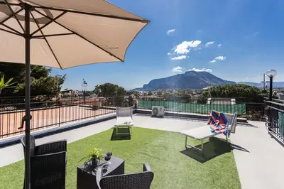 a pair of chairs and an umbrella on a patio at Mondello House Eraclea in Mondello