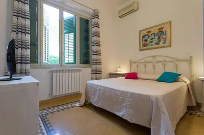 a bedroom with a bed and a tv and windows at Mondello House Eraclea in Mondello