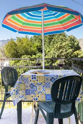 a table with an umbrella and two glasses of wine at Mondello House Eraclea in Mondello